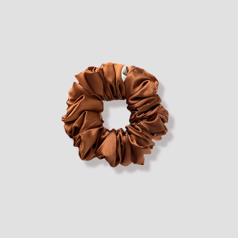 This is a picture of our petite brown scrunchie named Koper. It has hues of gold and red making it a nice golden-copper color which shines beautifully in sunlight. The elastic is 8 to 9 inches around. Fun Fact: Koper means copper in Danish.