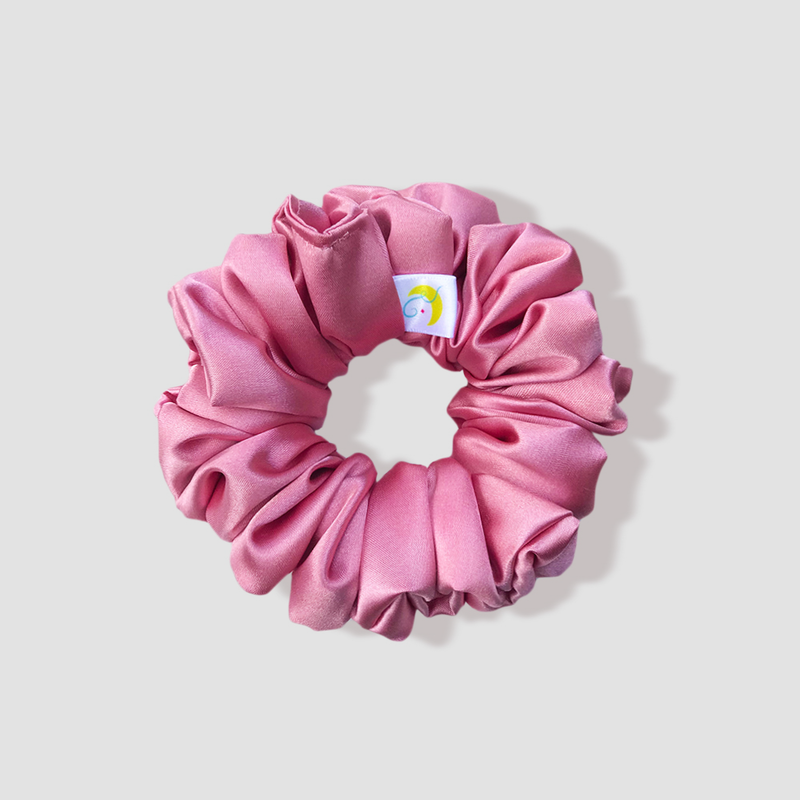 This is a picture of our rose gold scrunchie named Rosé. It is a pretty pink color with hints of metallic sparkle. The elastic is 8 to 9 inches around. Fun Fact: Rosé means pinkish in French.