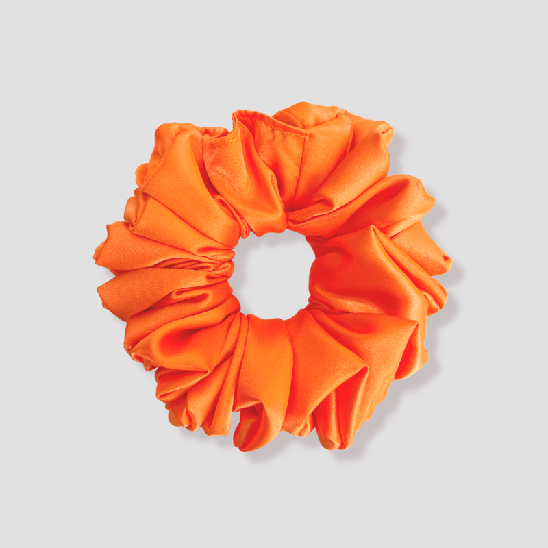 This is a picture of our orange scrunchie named Carrotto. It is a gorgeous bright orange giving off cool Fall or Summer vibes. The elastic is 8 to 9 inches around. Fun Fact: This vibrant scrunchie was named after an orange carrot